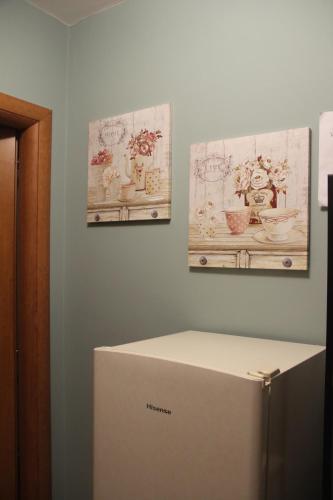 a refrigerator in a room with two paintings on the wall at Casa Vacanze Sud e Magia in Castelmezzano