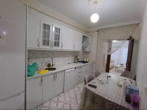 a kitchen with white cabinets and a table at Merkezi konumda aile için uygun in Kilis