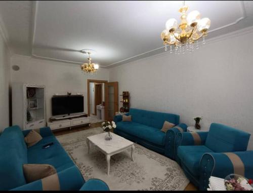 a living room with blue couches and a tv at Merkezi konumda aile için uygun in Kilis