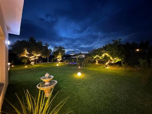 luxury villa rentals in tetùan في تطوان: ساحة في الليل مع أضواء على العشب
