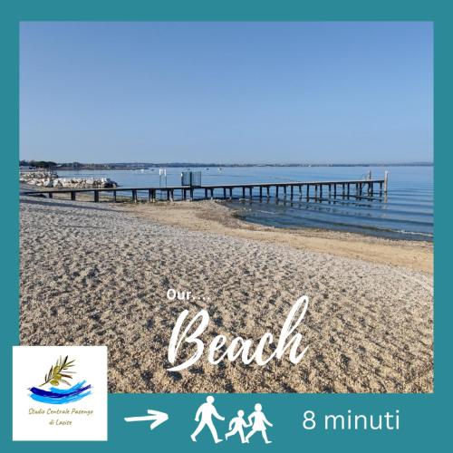 a poster for a beach with a family walking on the beach at Studio Centrale Pacengo di Lazise in Lazise