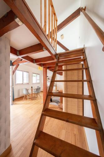 Un escalier en bois mène à une mezzanine. dans l'établissement Lovely little house with private garden in Paris, à Ivry-sur-Seine