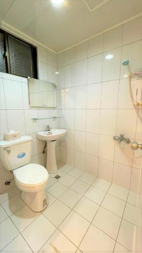 a bathroom with a toilet and a sink at 逢甲福舍 in Hsia-shih-pi