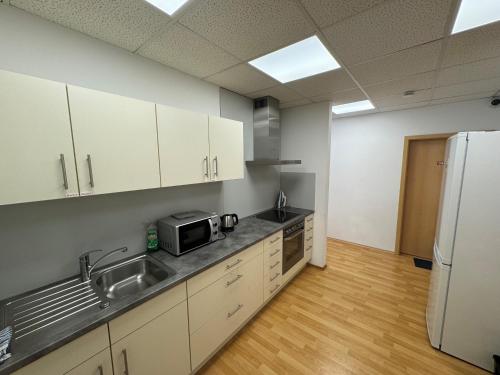 an empty kitchen with a sink and a refrigerator at Pension Schweizer in Laupheim