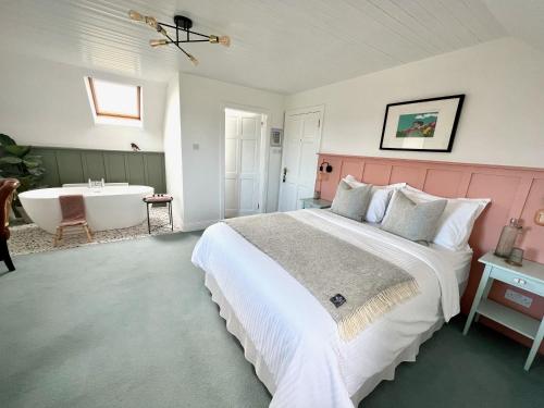 a bedroom with a large bed and a bath tub at Thistledown Lodge in Fethard on Sea