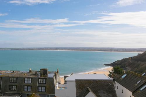 a view of a beach with buildings and the ocean at Happy Days in St Ives
