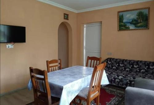 uma sala de jantar com uma mesa e um sofá em Bağ evleri, villalar em Qǝçrǝş