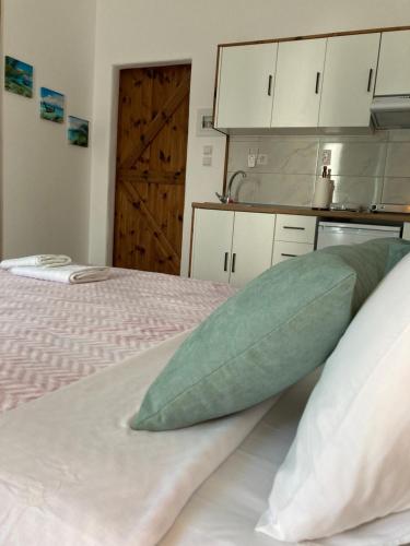 a bedroom with a bed with a green pillow on it at Soultana’s house in Mourteri