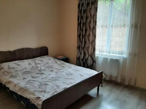 um quarto com uma cama e uma janela com cortinas em Bağ evleri, villalar em Qǝçrǝş
