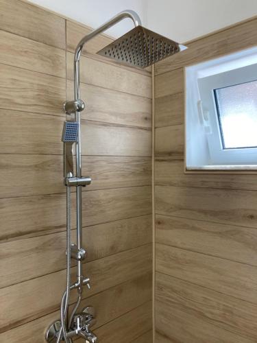 W łazience z drewnianą ścianą znajduje się prysznic. w obiekcie Soultana’s house w mieście Mourteri