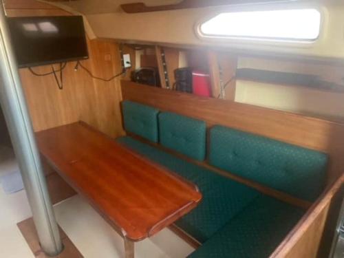 eine Holzbank in einem Zimmer mit Stühlen und einem TV in der Unterkunft Sailboat Experience in Annapolis in Annapolis