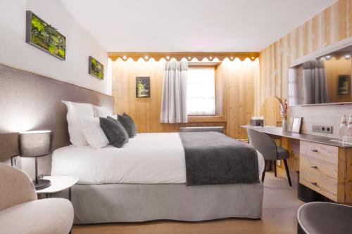 a hotel room with a bed and a desk at La Ferme du Golf in Megève