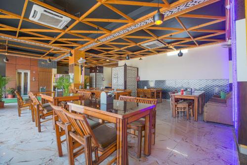 een eetkamer met houten tafels en stoelen bij Hotel Square Philip in Banūr