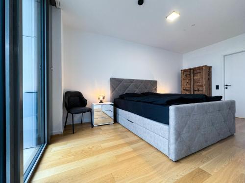 een slaapkamer met een bed en een stoel erin bij LUXUS-Apartment mit Weitblick in Wenen