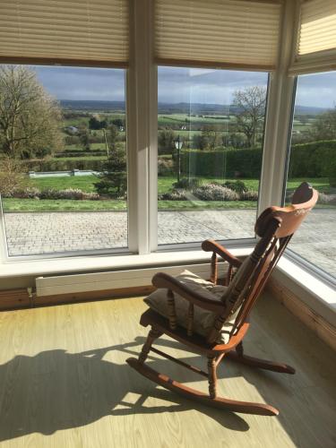 a rocking chair sitting in front of a window at Garrenmore Lodge B&B in Tipperary