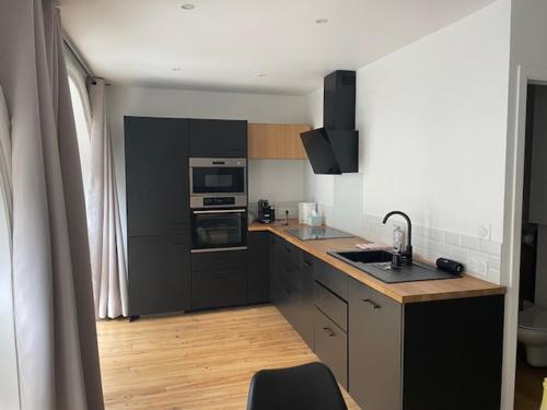 une cuisine avec un évier et une cuisinière four supérieur dans l'établissement T3 au pied des pistes CAUTERETS, à Cauterets