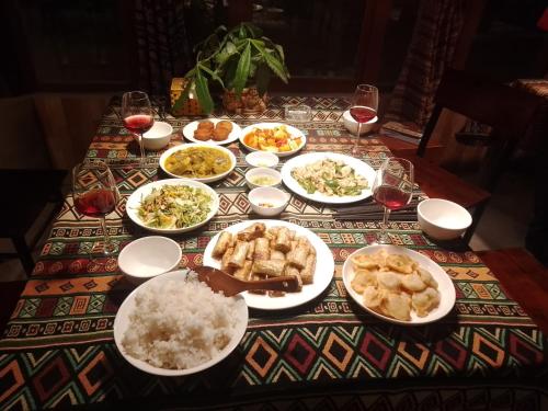 a table topped with plates of food and rice at Surelee Homestay in Sa Pa