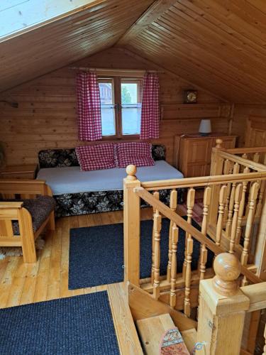 a room with a bed and a staircase in a cabin at Penzion Havran in Ždiar