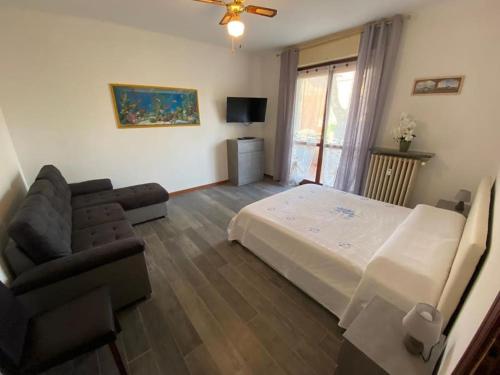 a bedroom with a bed and a couch and a television at La terrazza con le biciclette a due passi dal lago in Arona
