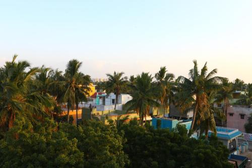 a view of a city with palm trees and buildings at Hotel Saibala Inn in Chennai