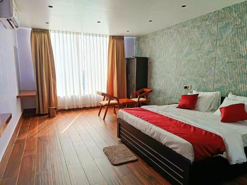 1 dormitorio con 1 cama, 1 mesa y 1 silla en Universal Hotel, en Bongaigaon