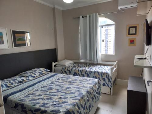 1 dormitorio con 2 camas y ventana en Suíte Aconchegante en Belém