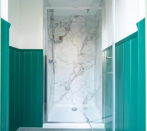 a bathroom with a shower with a white marble at Cobleland Campsite in Gartmore
