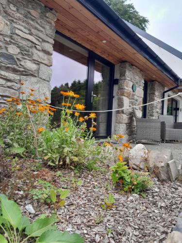 a stone house with a garden with flowers at K2Cottages in Kilday