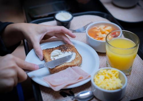 a person cutting a piece of toast with a knife at Faz Hostel in Córdoba