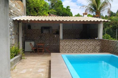 um pátio com uma piscina e uma casa em Casa Muro de Pedra / Cabrália em Santa Cruz Cabrália