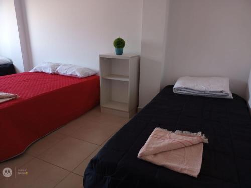 a room with two beds and a table with a plant at Hotel Costa Ballena in Puerto Madryn