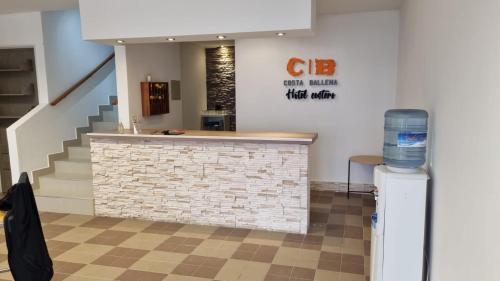 a lobby with a bar with a staircase in the background at Hotel Costa Ballena in Puerto Madryn