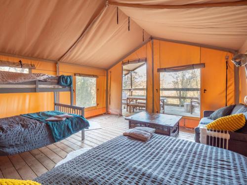 um quarto numa tenda com uma cama e uma mesa em Cobleland Campsite em Gartmore