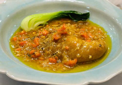 a white bowl of food with broccoli and sauce at Grand Maison W 館山美食倶楽部 in Tateyama