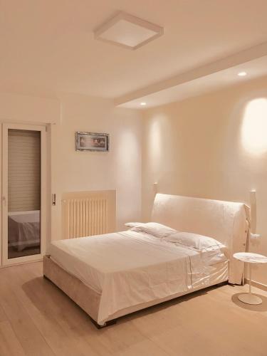 ein weißes Schlafzimmer mit einem Bett und einem Tisch in der Unterkunft Huis 8 in Pescara