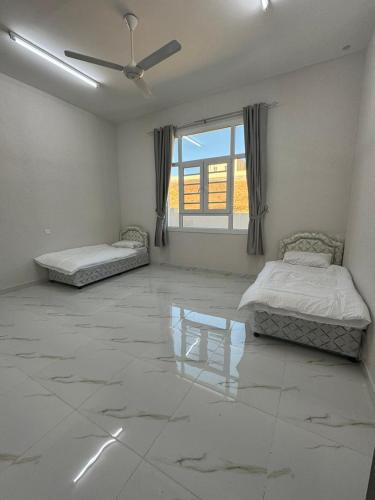 a large room with two beds and a window at Jabal Shams, Al Noor house جبل شمس in Misfāh