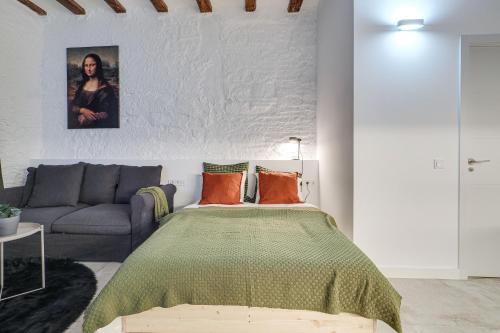 a bedroom with a bed and a couch at Luxury 1BR BORN in Barcelona