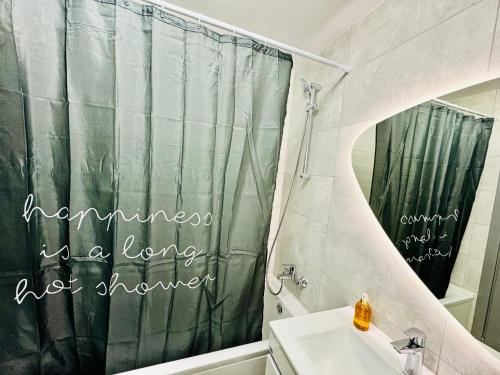 a bathroom with a shower curtain that reads happiness is a long not shower at Altheda Living Avanera 9B-144 in Suceava