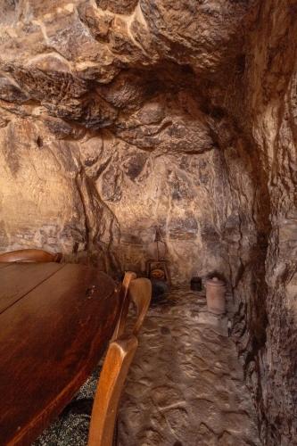 a cave with a wooden bench in a stone cave at Si-Moutique, le Case-grotte degli Avi 2 in Modica