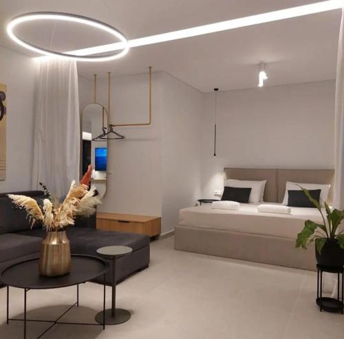 een slaapkamer met een bed, een tafel en een bank bij BlueMotion - MediSuite in Piraeus