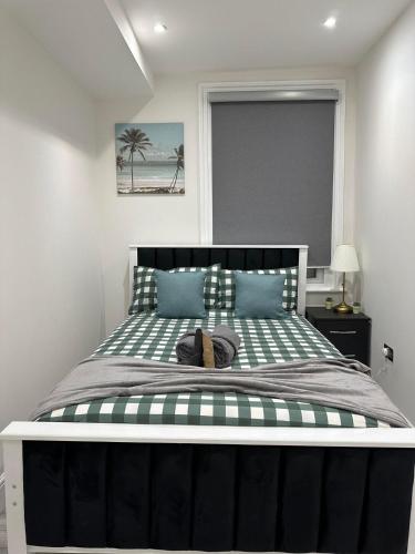 a bedroom with a large black and white bed at Studio flat in London in London