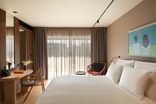 um quarto de hotel com uma cama grande e uma secretária em Dusit Suites Athens em Atenas