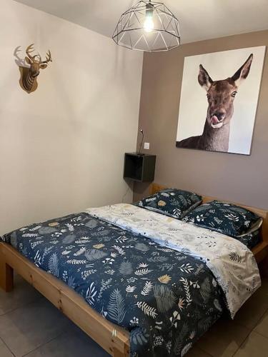 - une chambre dotée d'un lit avec une photo de cerf sur le mur dans l'établissement Gîte la biche des écrins, à Prunières