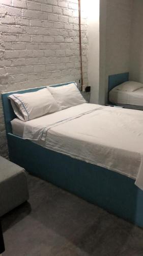 Bett mit weißer Bettwäsche und Kissen in einem Zimmer in der Unterkunft Hotel Casa Victoria Rodadero in Gaira