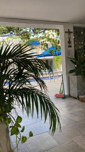 eine offene Tür zu einer Terrasse mit blauen Sonnenschirmen in der Unterkunft Hotel Casa Victoria Rodadero in Gaira