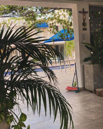 a patio with blue umbrellas and a plant at Hotel Casa Victoria Rodadero in Gaira