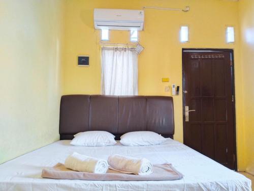 Un pat sau paturi într-o cameră la Risqia Homestay Syariah by Cocotel