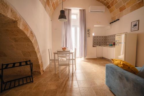 a kitchen with a table and a refrigerator in a room at Casa Marina in Polignano a Mare