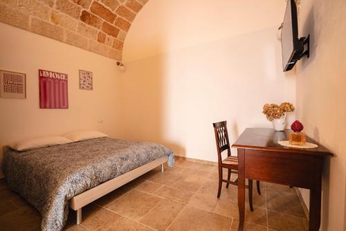 a bedroom with a bed and a table and a desk at Casa Marina in Polignano a Mare