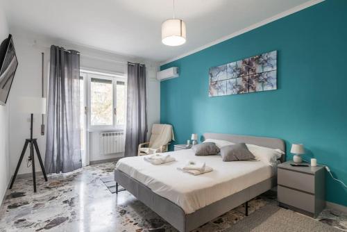 Dormitorio azul con cama y pared azul en Ostiense Apartment Self check-in, en Roma